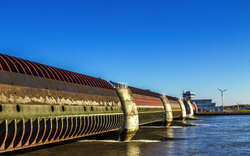 Große Schleusenanlage an einem Fluss bei klarem Himmel.