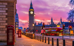 Big Ben und ein roter Bus bei Sonnenuntergang in London.